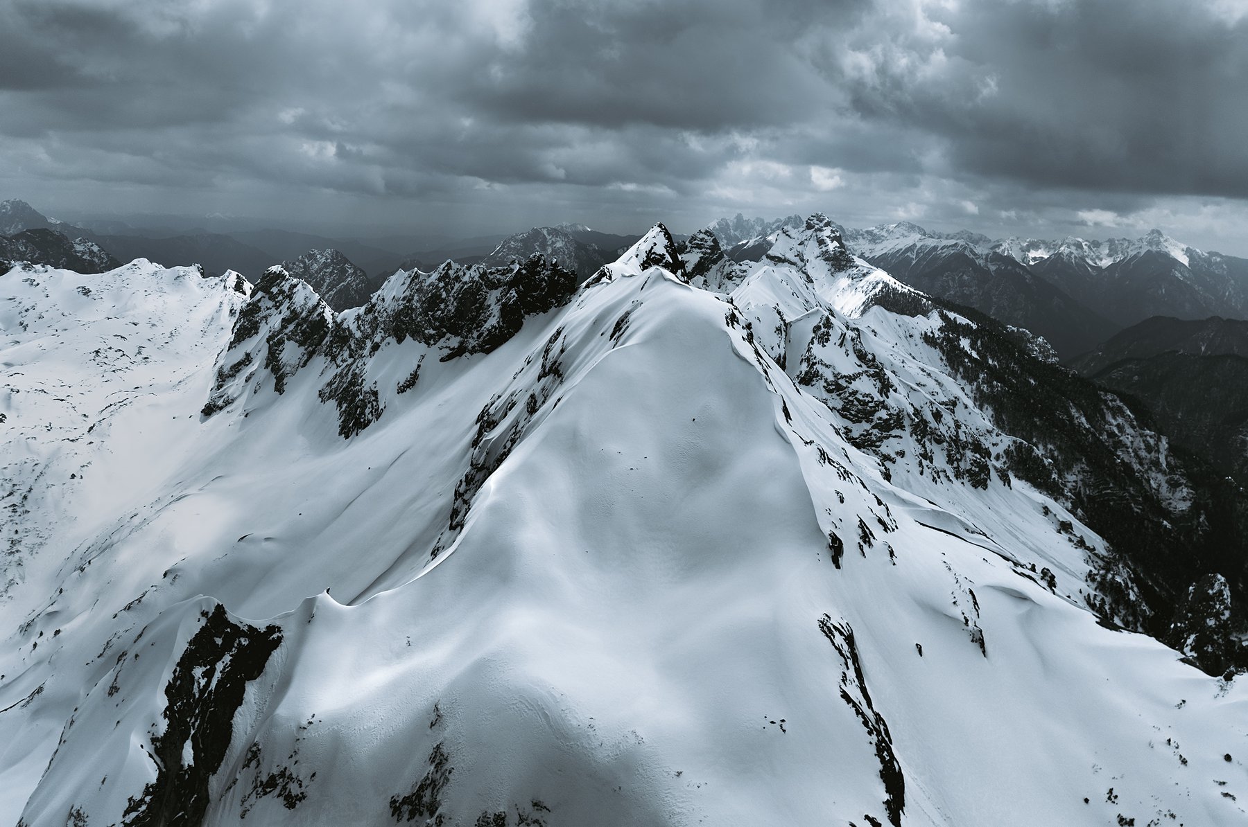 Snow-covered ridges beneath layered clouds