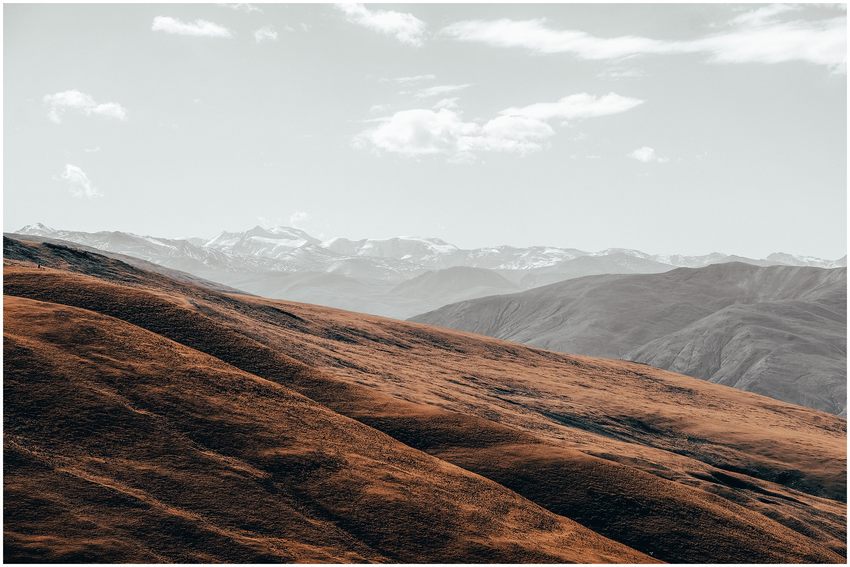 Warm-toned hills stretching toward distant mountain ranges