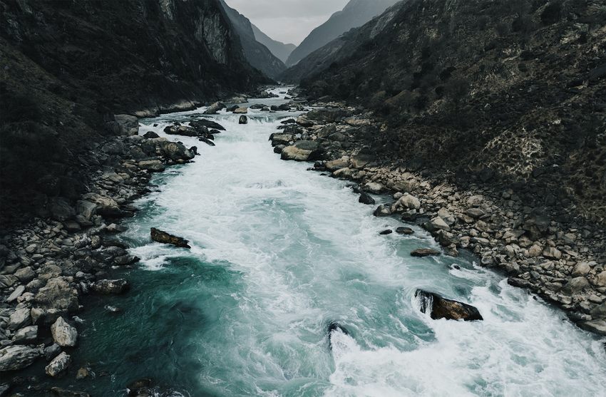 Pale blue rapids flowing through a rocky gorge