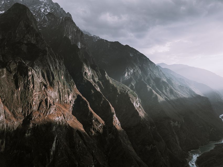 Steep rocky cliffs and a deep valley beneath clouds