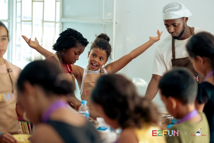 Children and instructors share a lively moment around the preparation table.