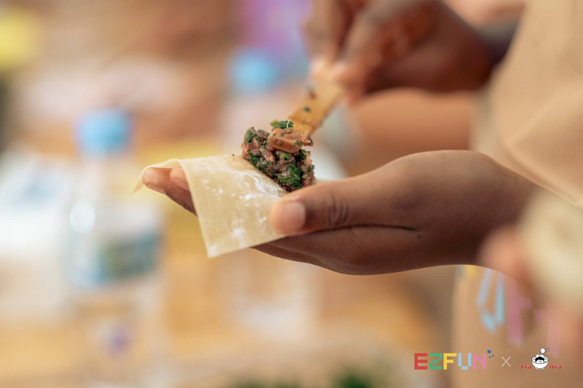 A spoonful of filling is placed onto a wonton wrapper held in one hand.