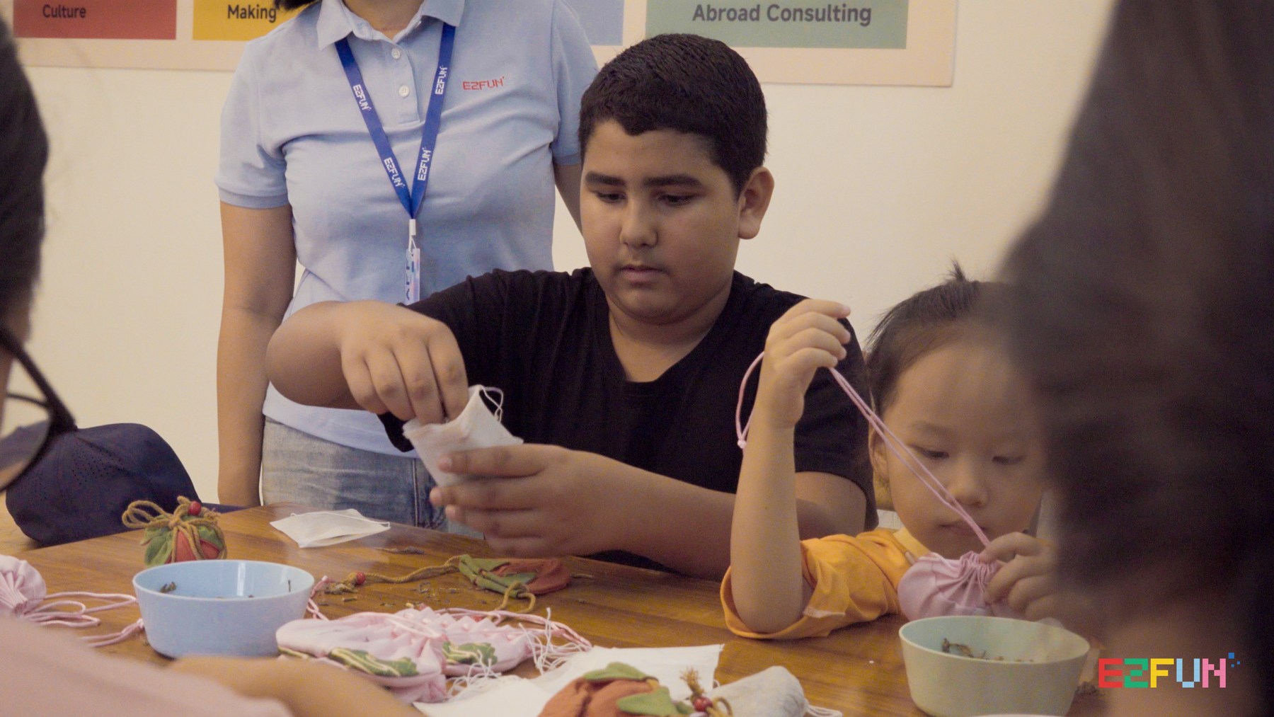 Children fill sachets and arrange their drawstrings around the table