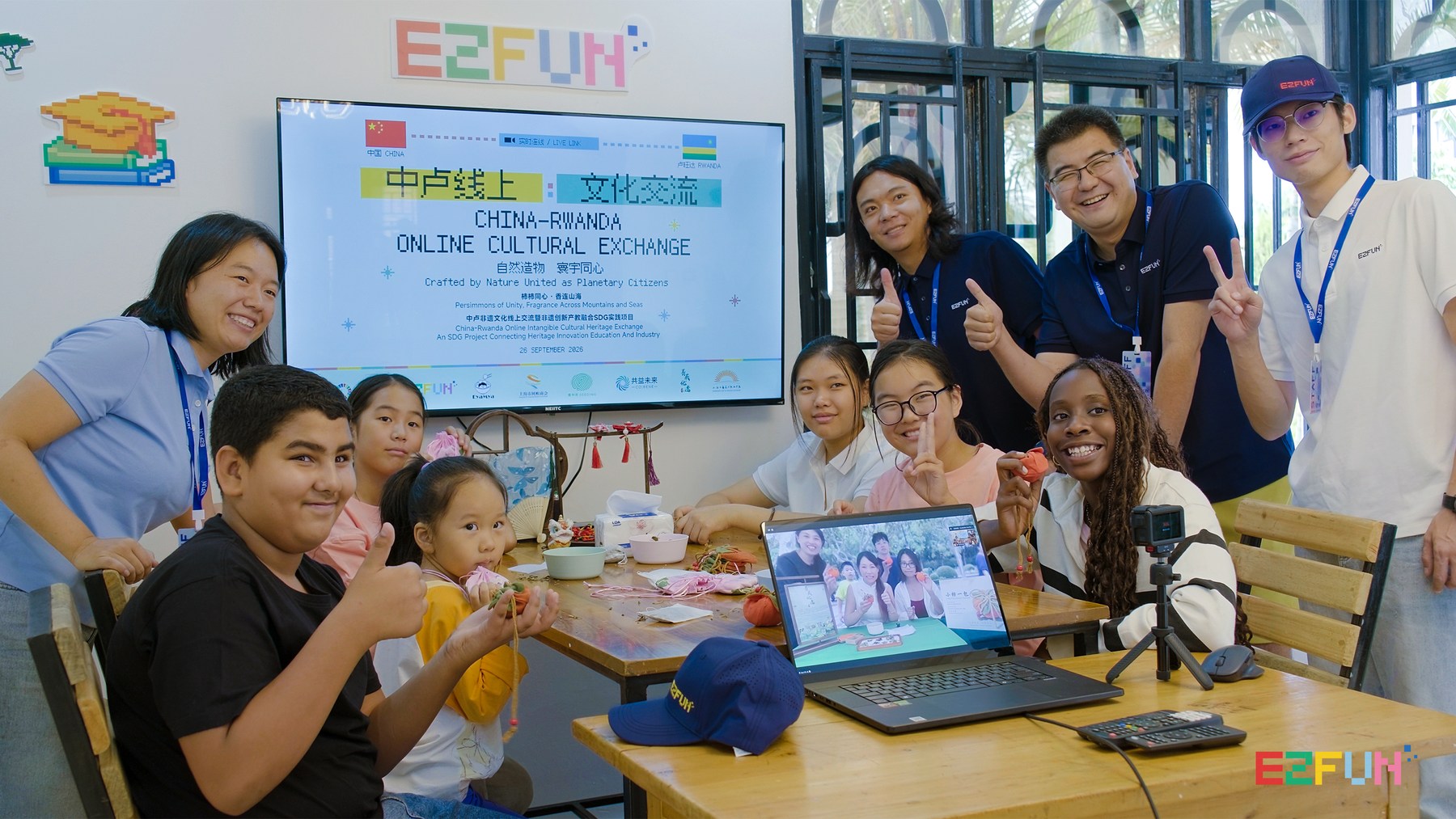 Participants hold their sachets beside a laptop showing the live exchange