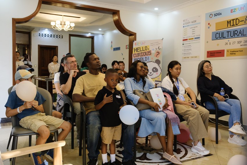 Adults and children listen together during the cultural introduction