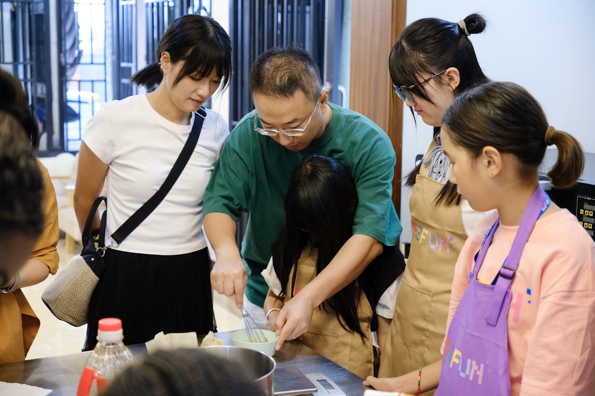 Family members prepare mooncakes together around the workshop table
