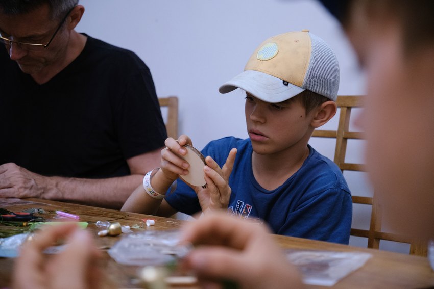 A young participant concentrates on assembling a handmade decoration