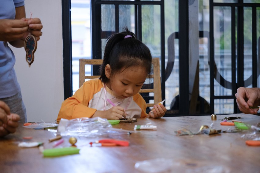 A younger child works on a festive craft alongside other participants