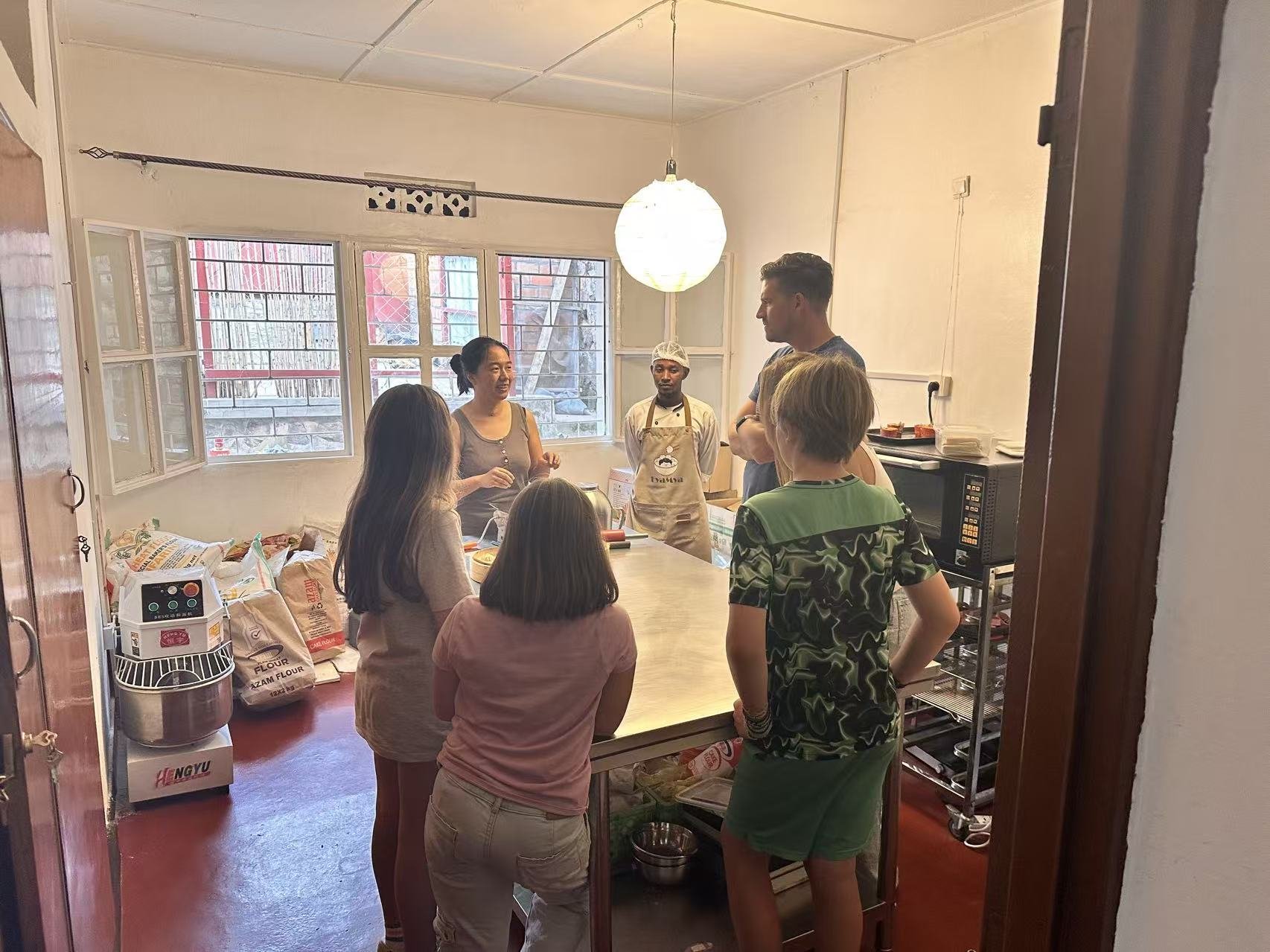 Participants gather around a kitchen worktop.