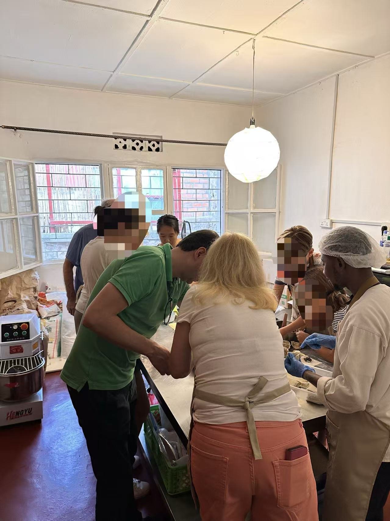 Participants continue talking in the kitchen while others work at the counter.